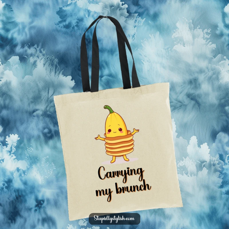 Funny tote bag with a banana character attempting to balance a tall stack of pancakes, showcasing a humorous food-related scenario.
